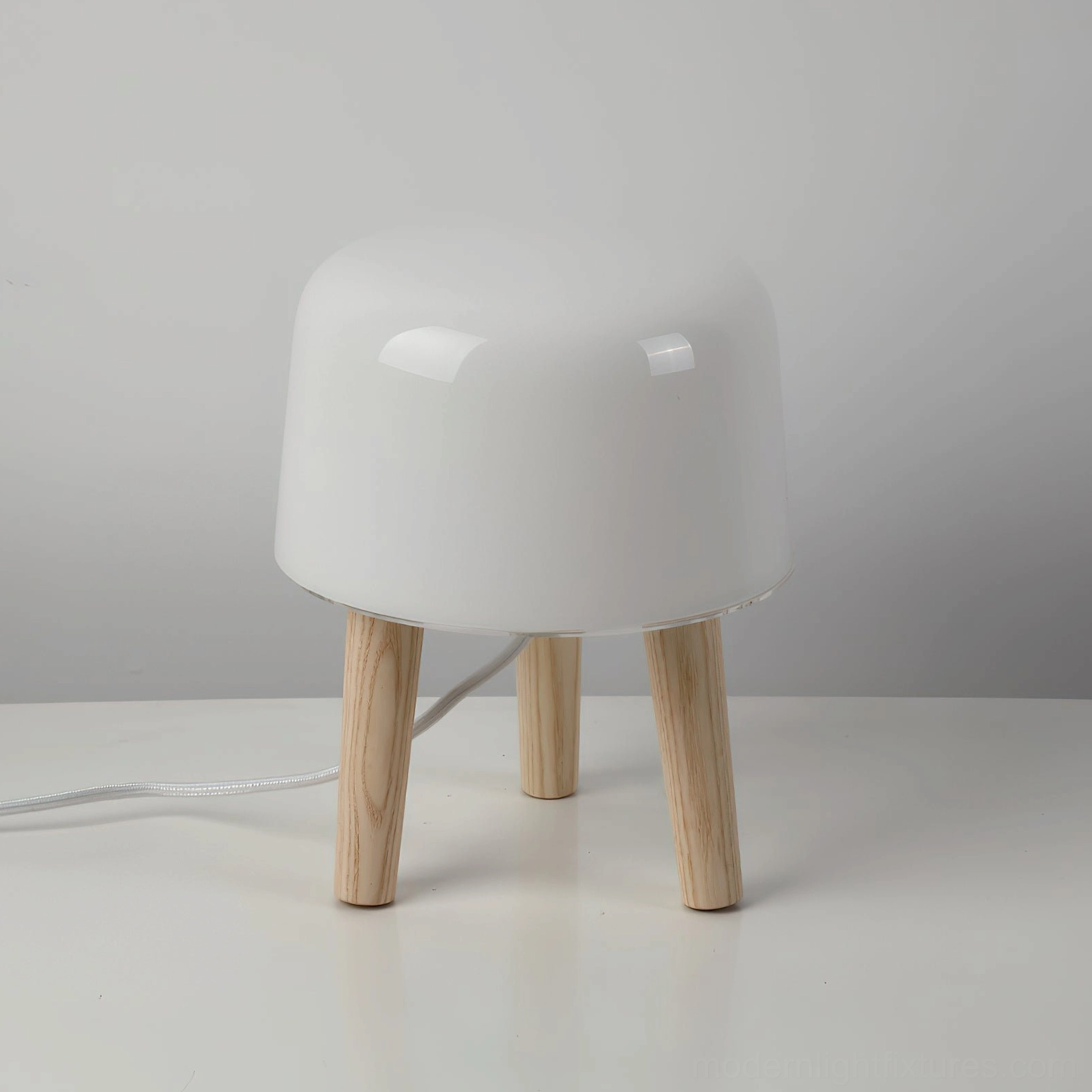Front three-quarter studio view of minimalist milk glass table lamp with natural light wood legs, clean Nordic aesthetic