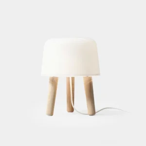 Front three-quarter view of minimalist milk glass table lamp with natural light wood tripod base on white background, showcasing Nordic minimalist design