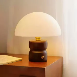 Modern mushroom table lamp on bedroom nightstand providing warm ambient lighting next to sheer curtains