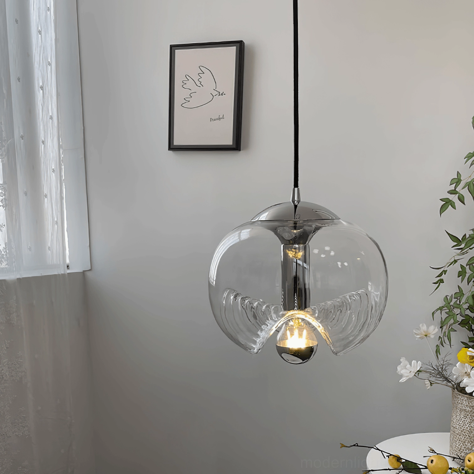 Minimalist wave pendant lamp in apartment corner setting with wall art and plants, showing Nordic design aesthetic and light diffusion