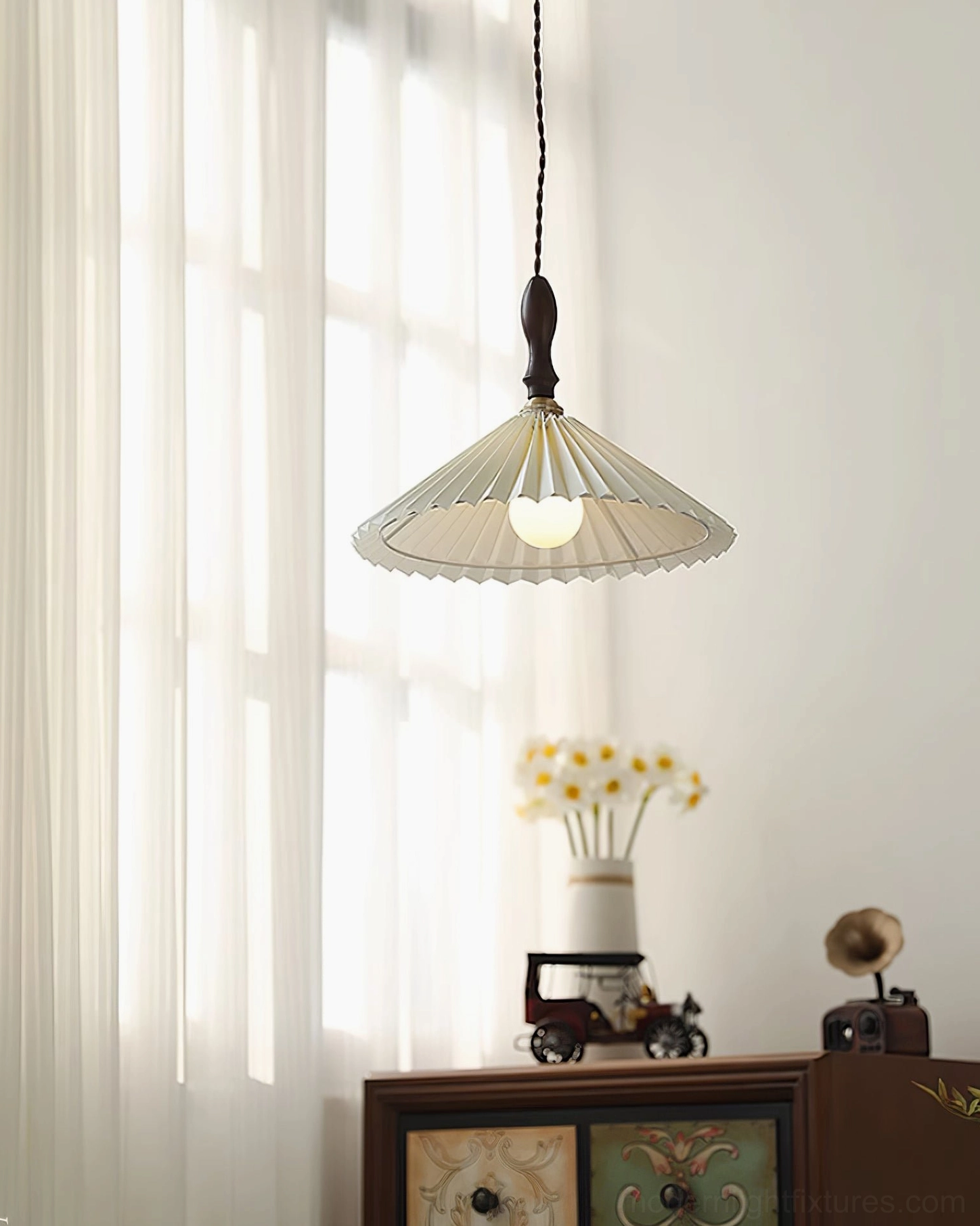 Pleated pendant lamp with soft warm lighting creating ambient illumination in minimalist setting