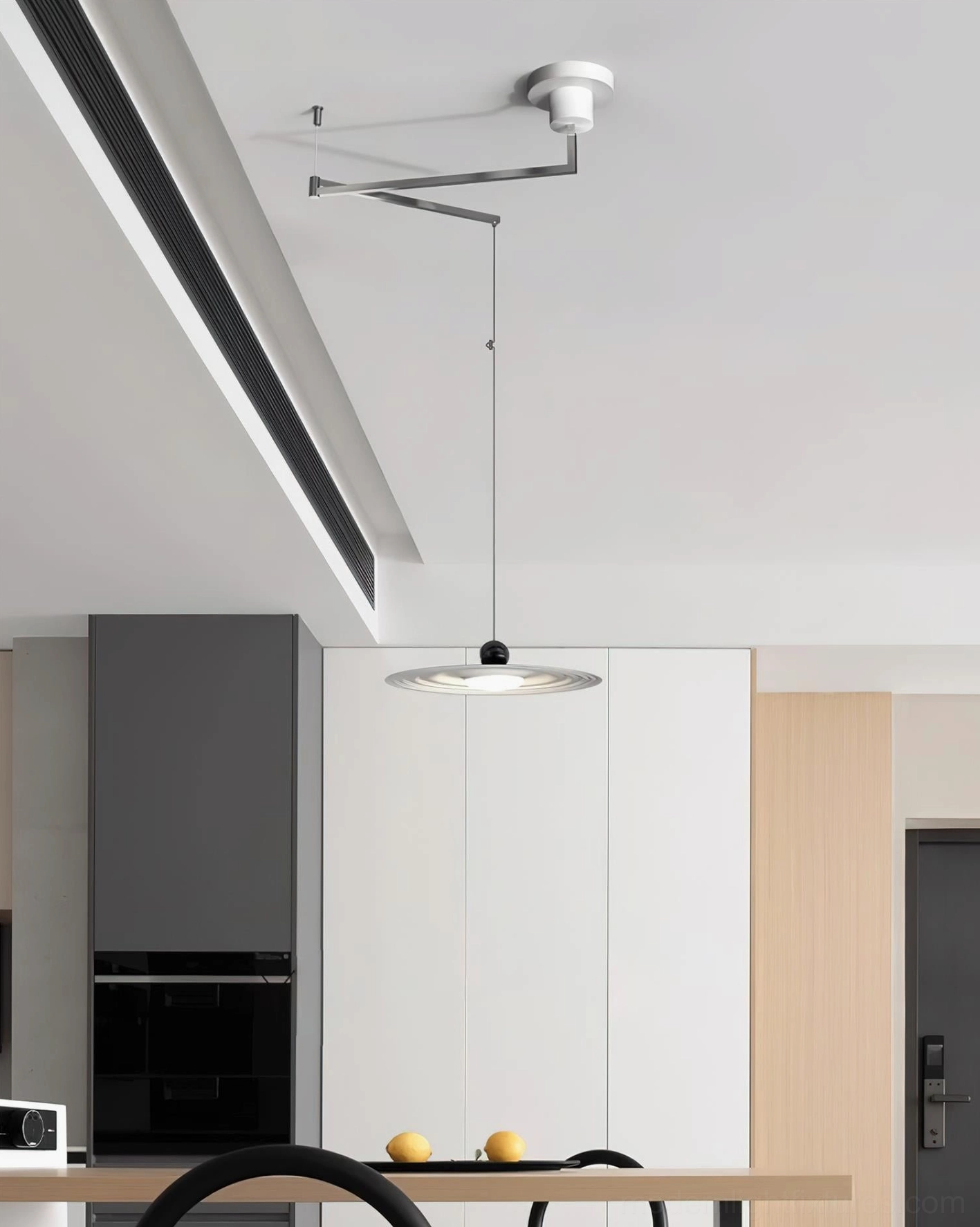 Minimalist pendant light with sleek silver-white hardware and compact rippled disc shade in home ceiling