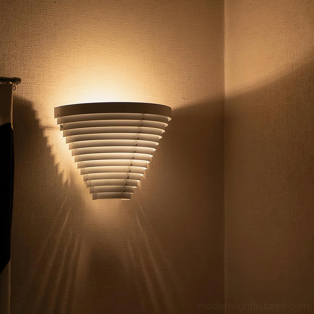 Architectural cone wall lamp mounted in room corner, casting radial light patterns on adjacent walls