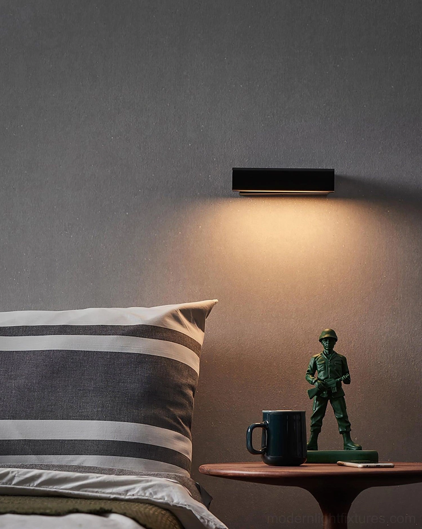 Minimalist wall lamp with wood accents and aluminum construction, installed in bedroom reading area