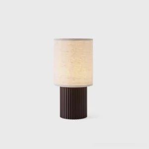 Modern minimalist wireless charging table lamp with ribbed dark brown metal base and natural beige fabric cylindrical shade, front studio view showcasing Scandinavian design