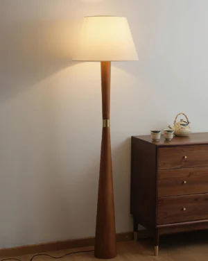 Scandinavian wooden floor lamp in walnut finish creating warm ambient light in living room corner with vintage wooden cabinet