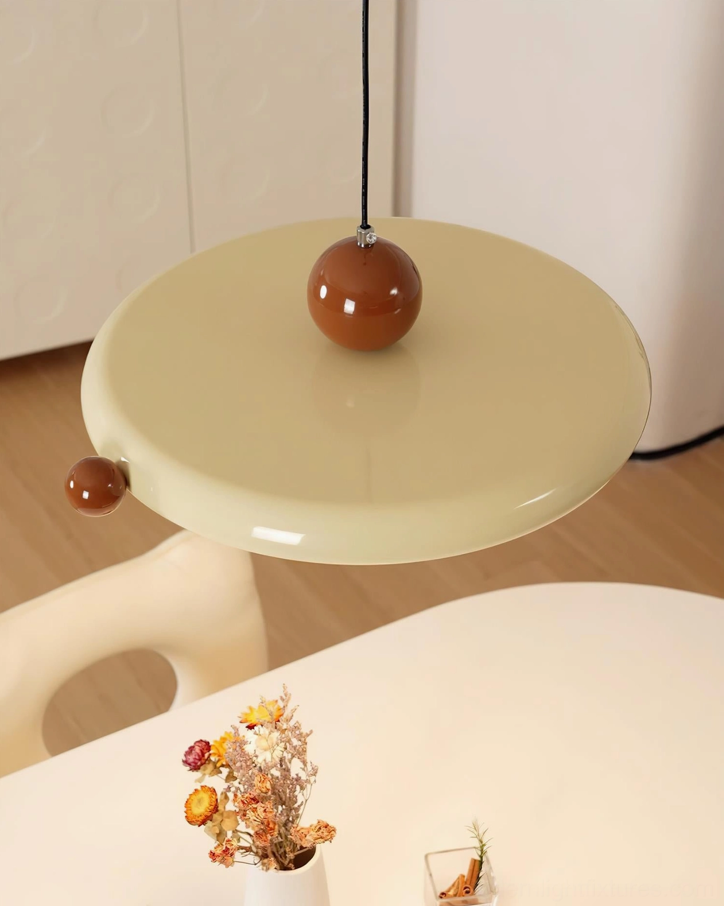 Low angle view of acrylic disc pendant lamp in residential dining space with wooden flooring
