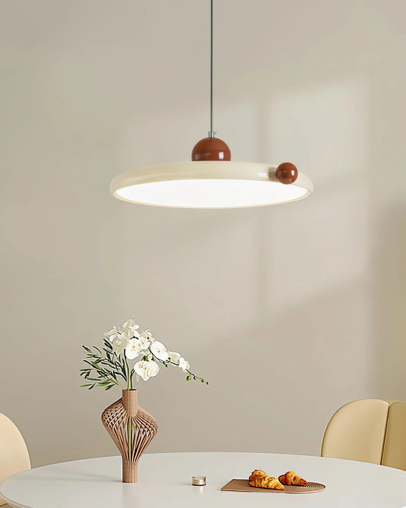 Minka geometric pendant light in modern dining room with warm illumination, table setting and decor