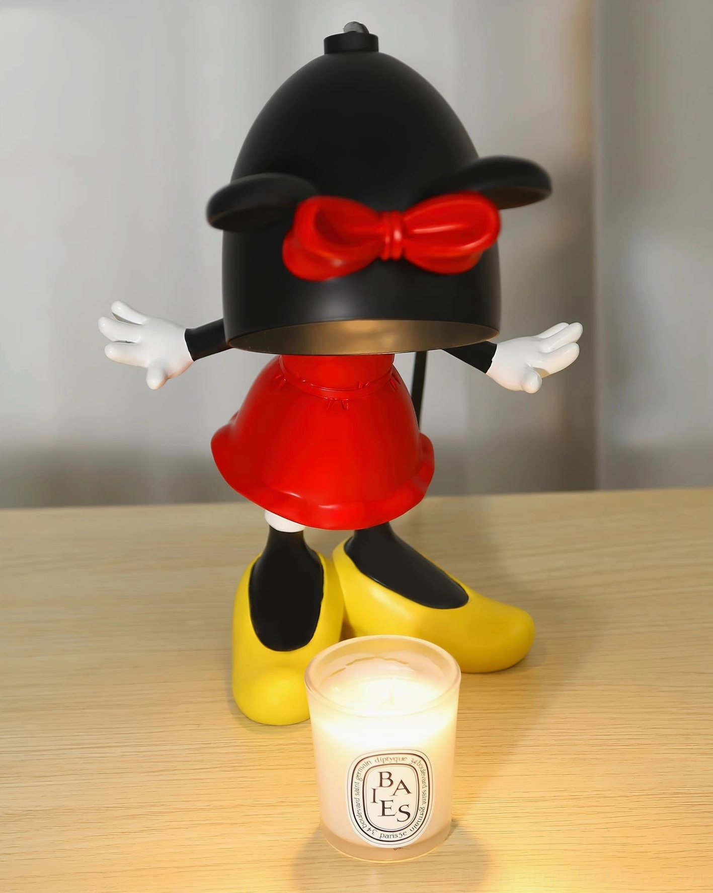 Minnie Mouse character candle warmer lamp with black and red color scheme on wooden desktop, scented candle warming demonstration