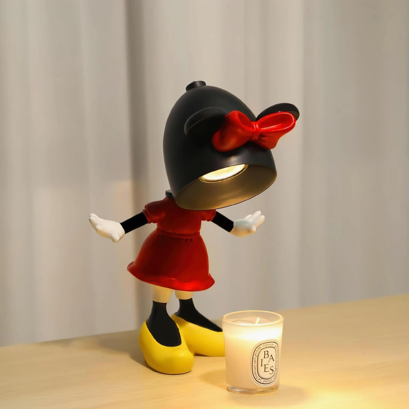Illuminated Minnie Mouse character candle warmer lamp with halogen bulb activated, warm ambient lighting on wooden desktop workspace