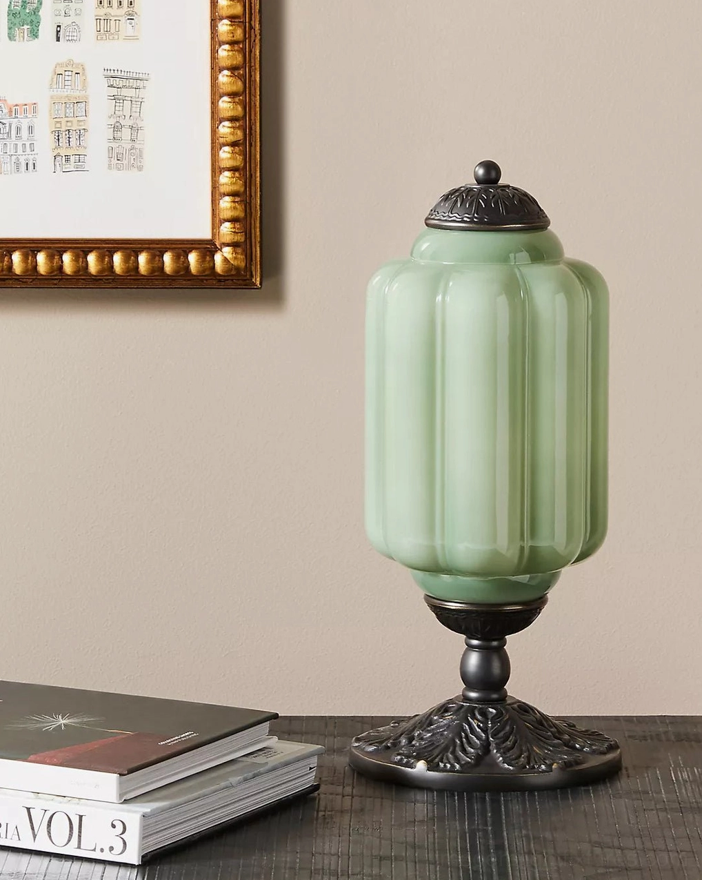 Mint green fluted glass table lamp with matte black bronze base in residential study desk display with books and wall art