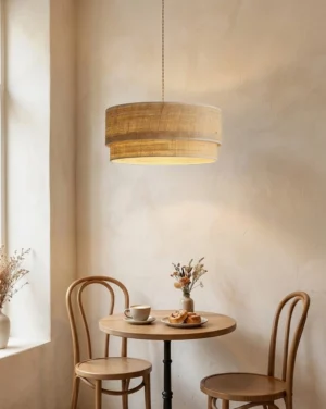 Mirella woven raffia pendant light hanging over small dining table in warm rustic nook with textured beige walls