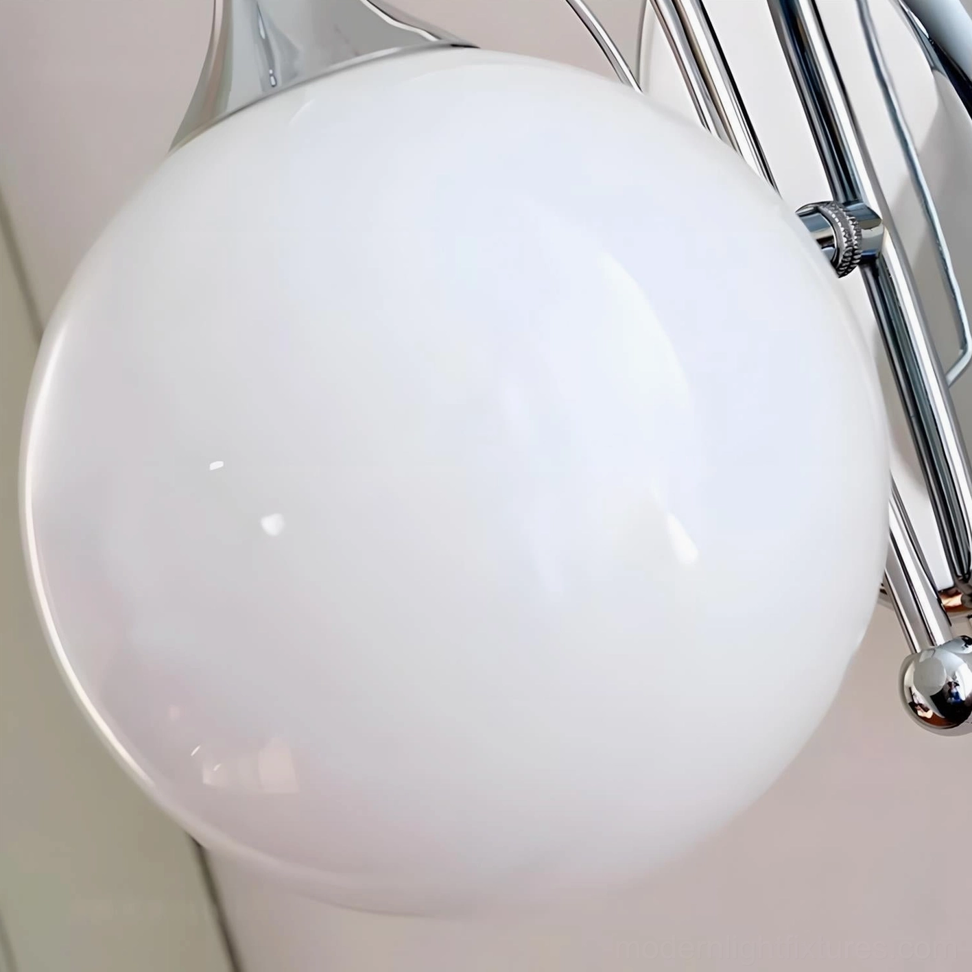 Mirelle Glo glass globe wall lamp in modern interior, sculptural curved chrome frame architectural lighting element