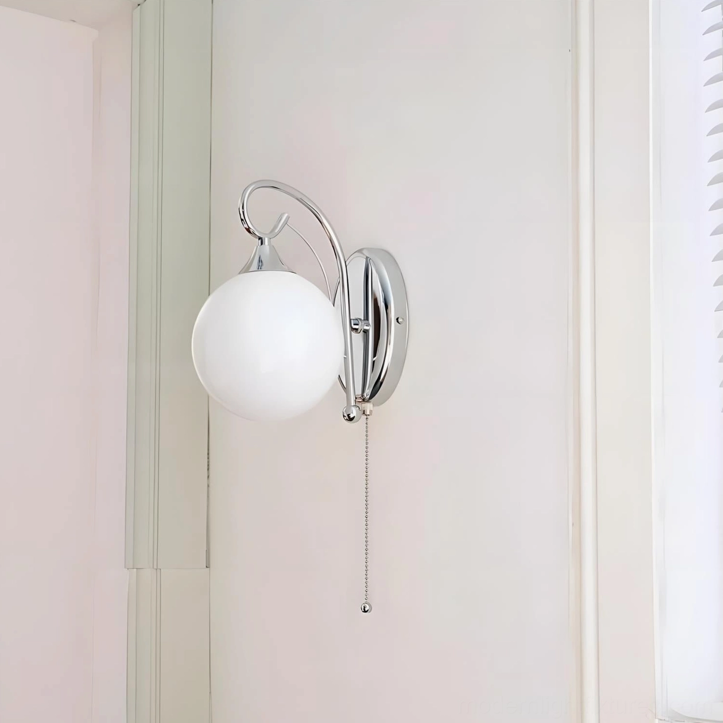 Modern wall-mounted sconce light fixture with frosted glass shade, chrome metal construction, home decor photography