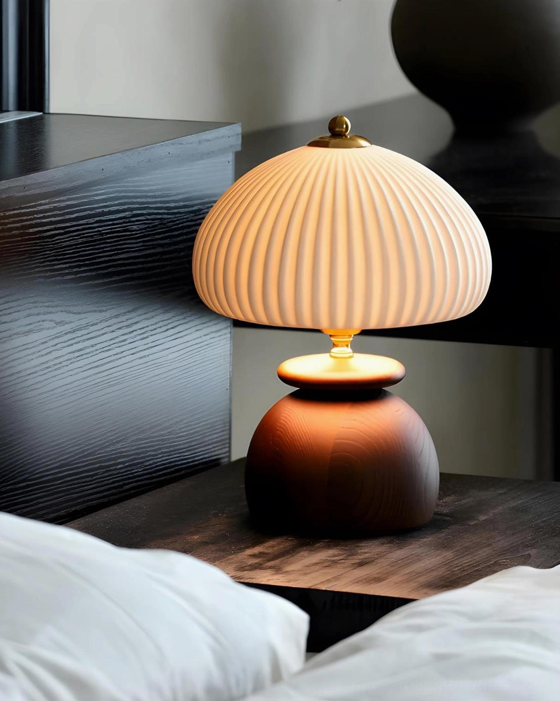Contemporary pleated dome table lamp with dark brown wooden base, bedside with made bed linens