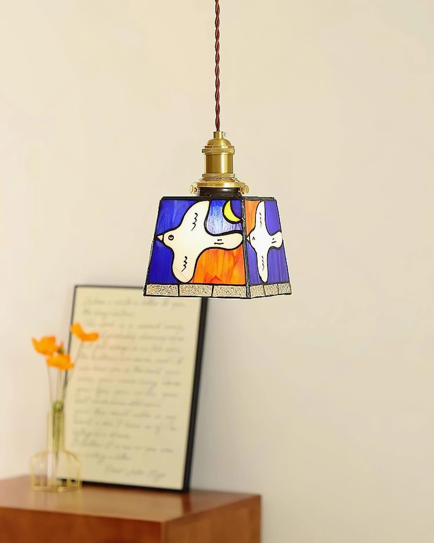 Miroa blue stained glass pendant light hanging above bedside table