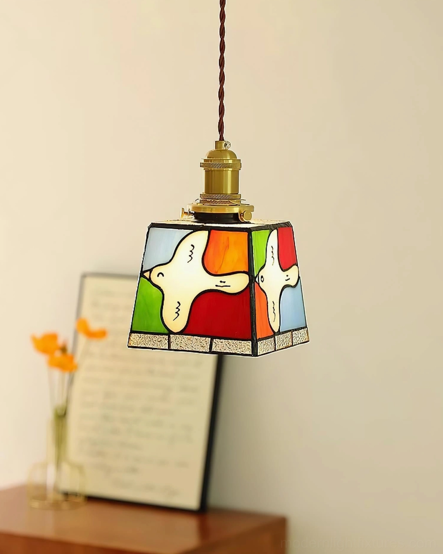 Miroa pendant lamp three-quarter view mounted above wooden bedroom furniture
