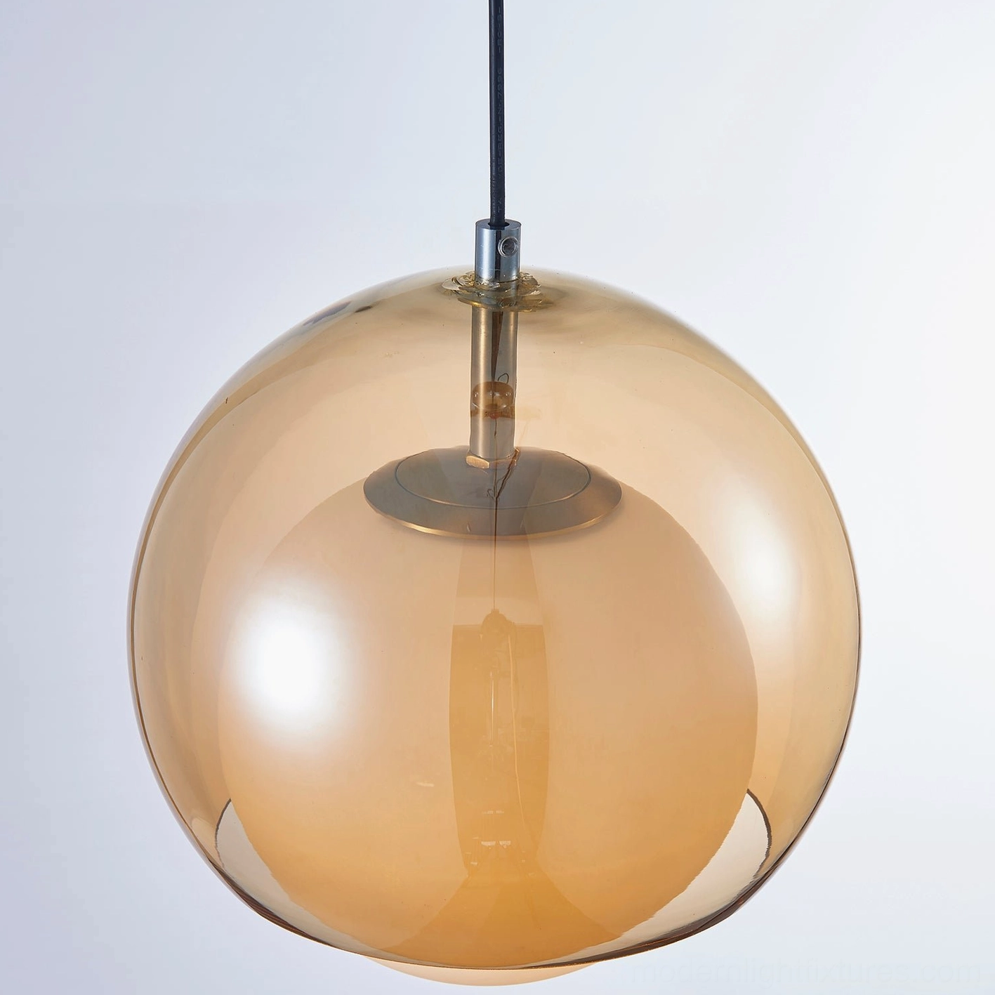 Misty cognac glass pendant light positioned in contemporary dining space with warm atmospheric glow