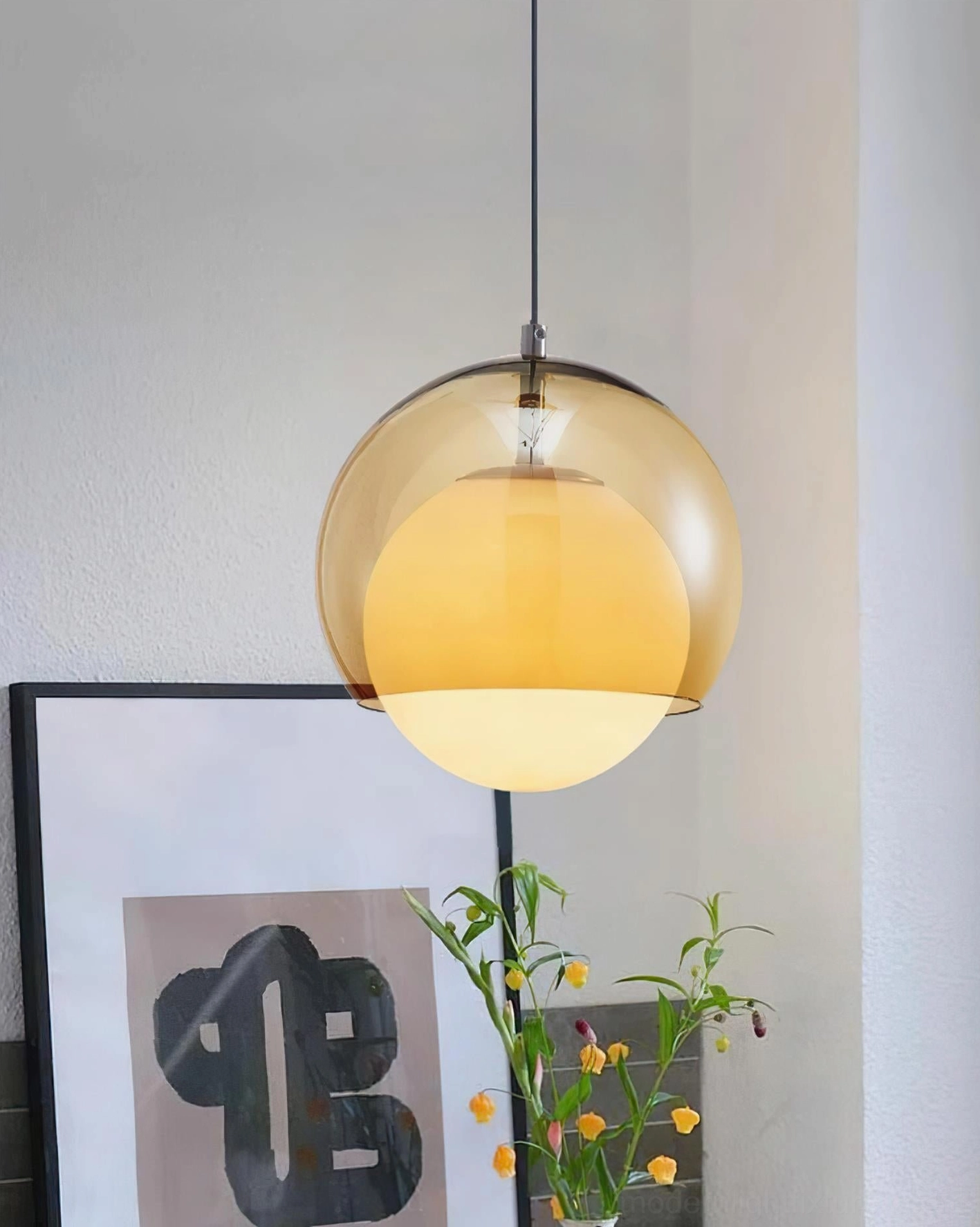 Amber glass pendant lamp in kitchen setting with decorative flowers and artwork - warm ambiance