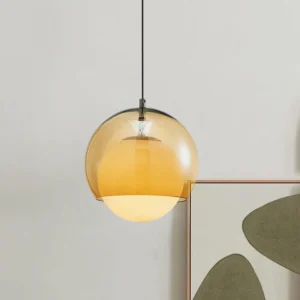 Modern frosted glass pendant light with black cord suspended in contemporary interior with abstract wall art