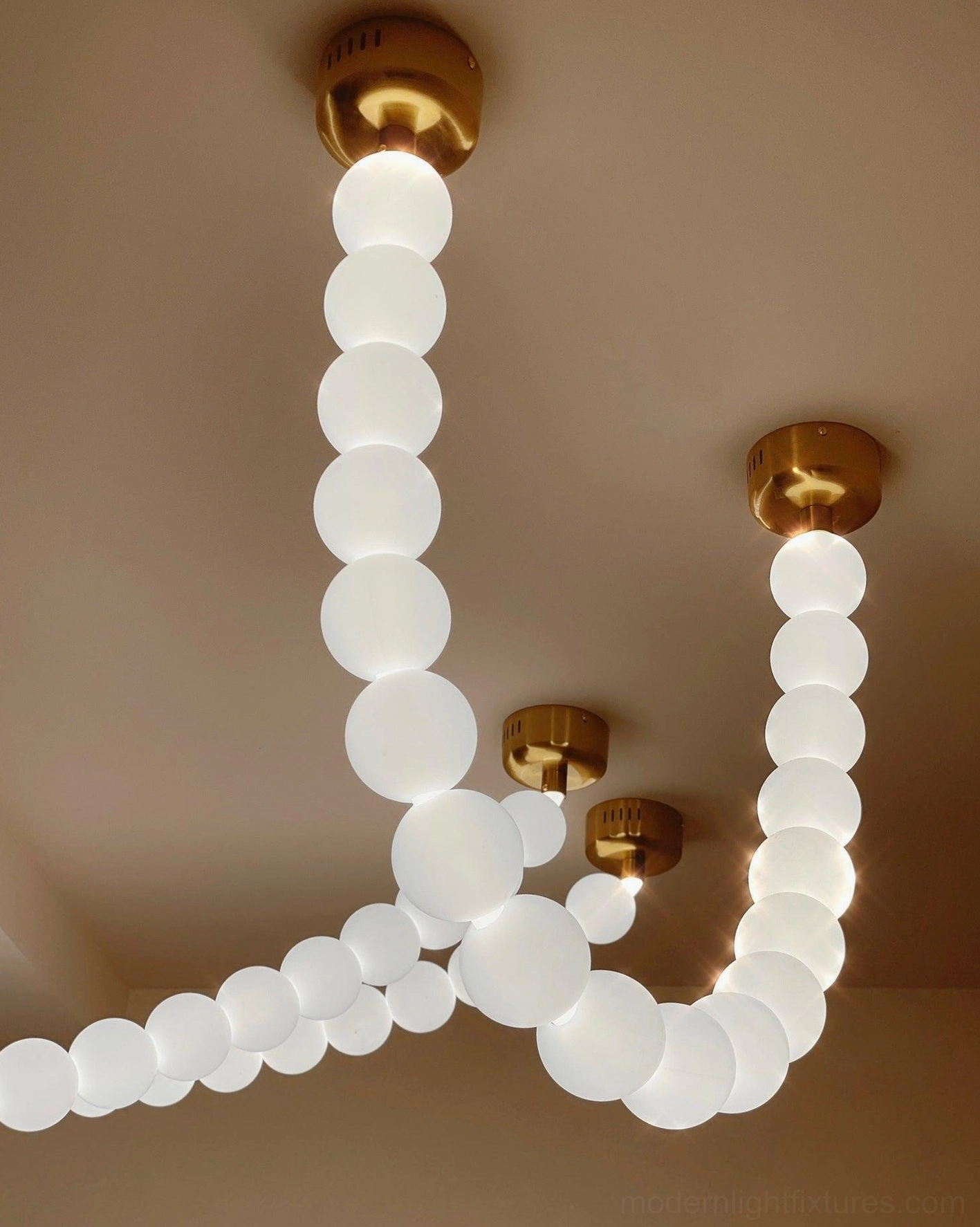 Pearl string chandelier showing multiple spheres with varied frosted and clear acrylic finishes