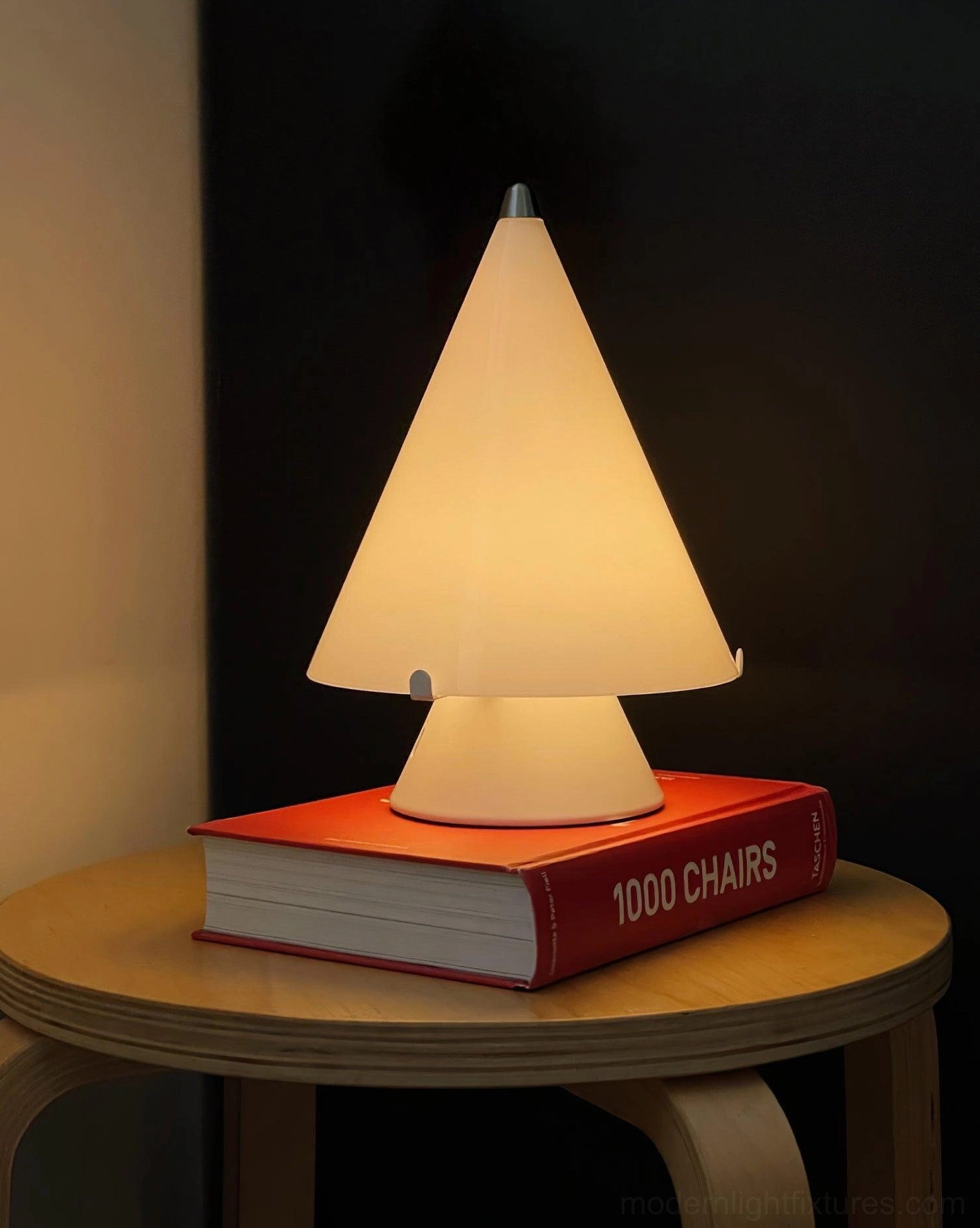 Miza contemporary table lamp side angle on round wooden side table with red hardcover book