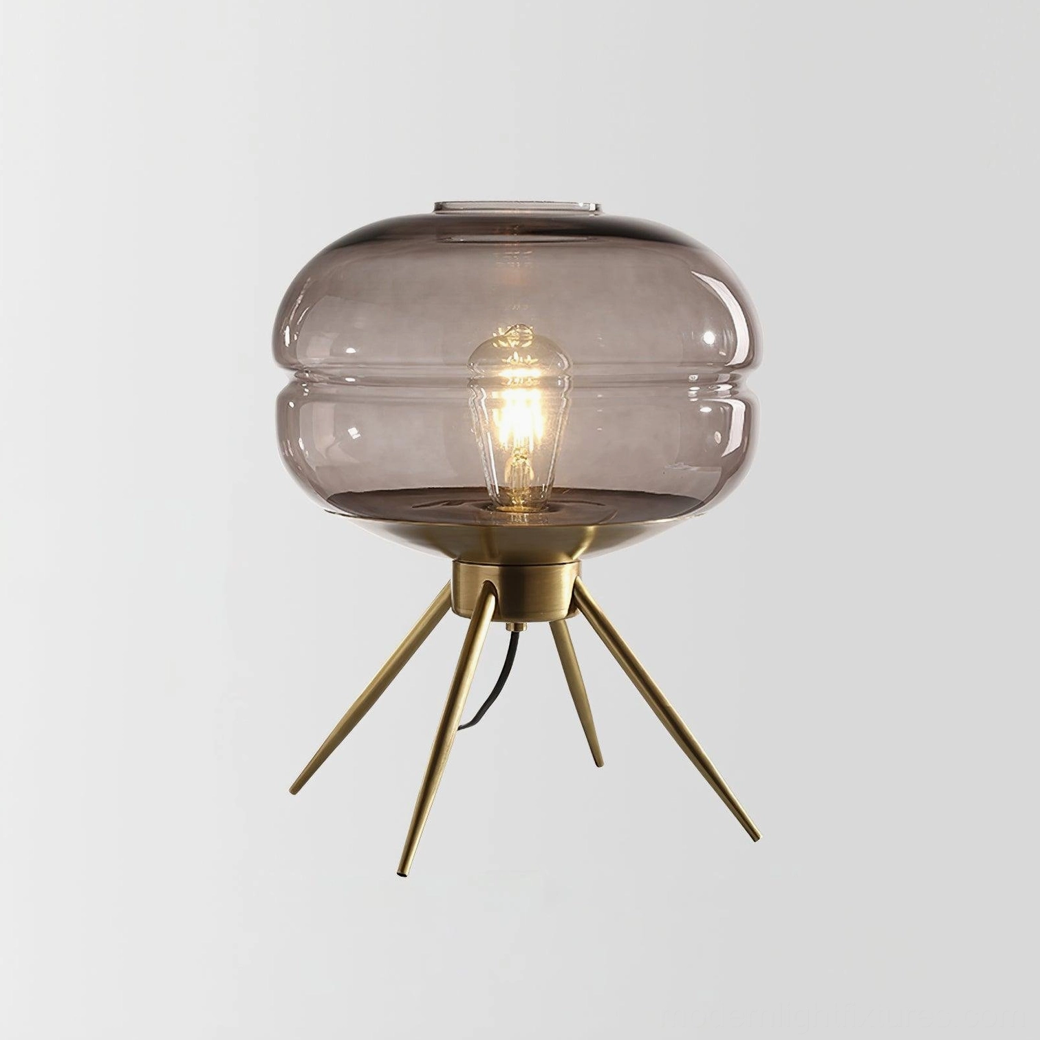 Smoke gray tiered glass table lamp with brass base centered studio product shot on white
