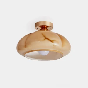 Modern amber glass semi-flush ceiling light with polished brass base, close-up product view on white background
