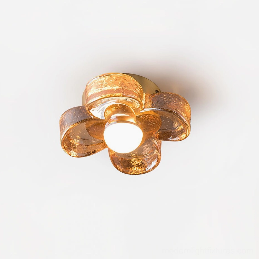 Four-leaf clover amber glass flush mount ceiling light with polished brass base, front overhead view