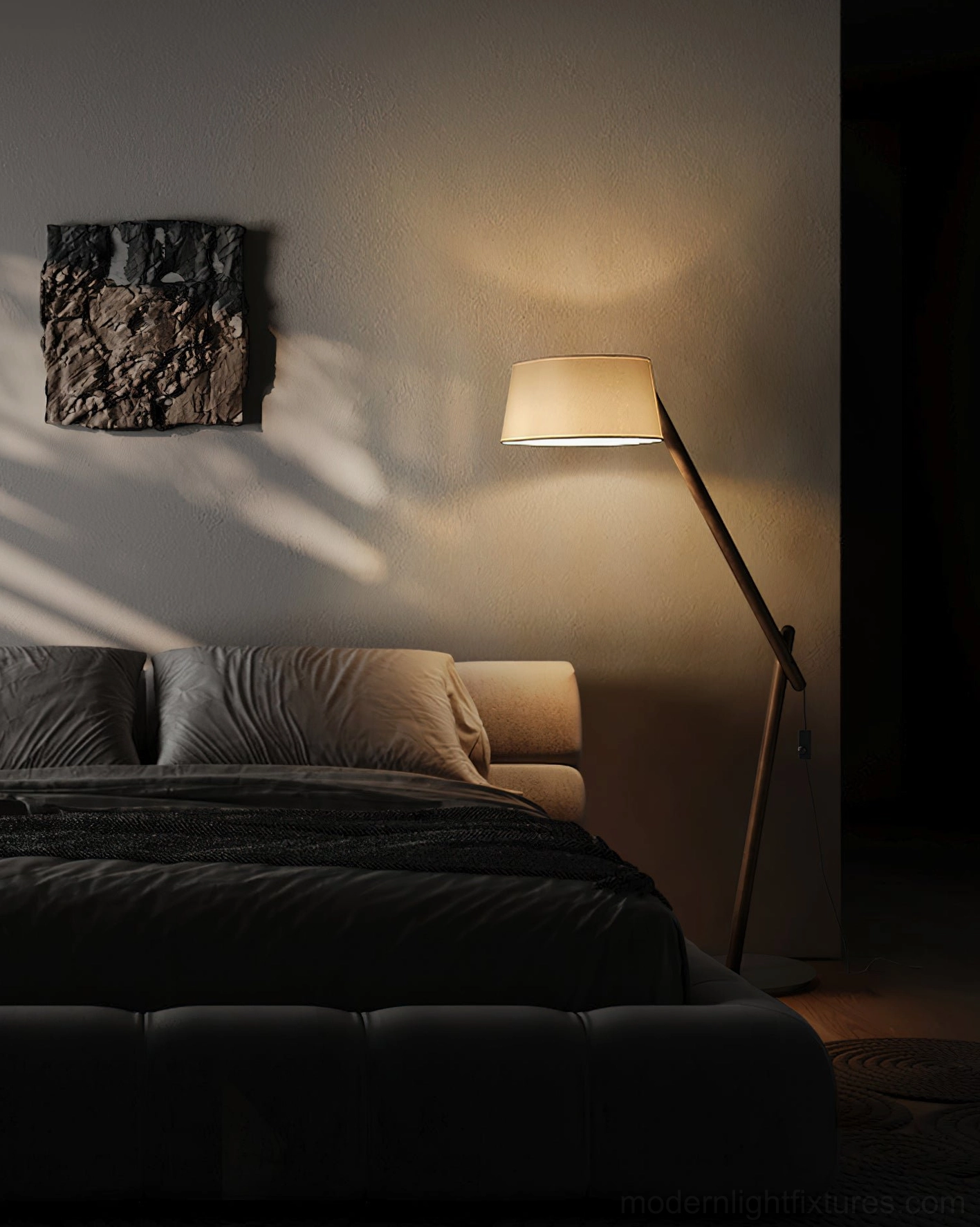 Contemporary bedroom floor lamp with dark metal arm providing warm ambient lighting beside luxury bedding
