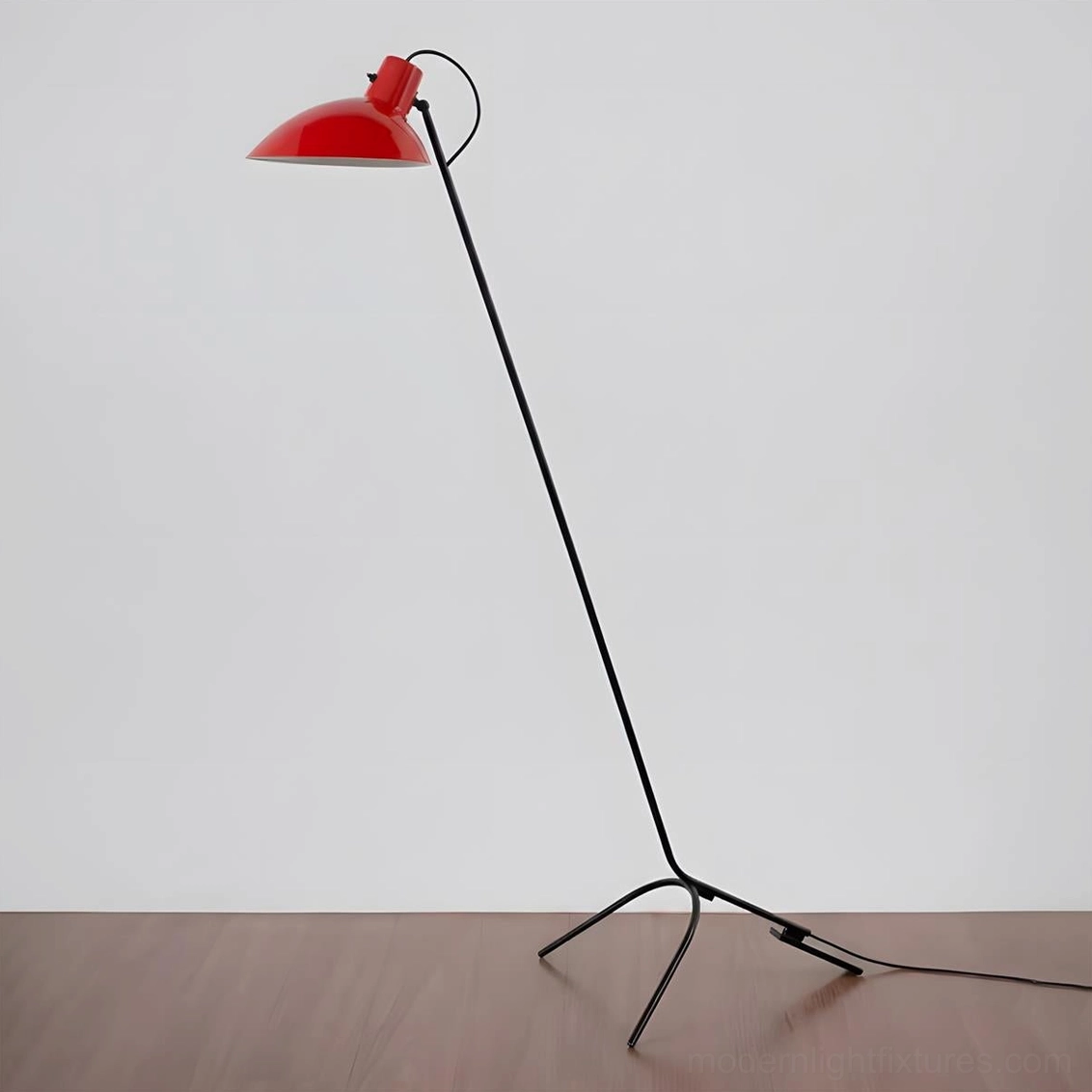 Modern arc tripod floor lamp black pole with red dome shade on wood floor, matte finish three-prong base detail