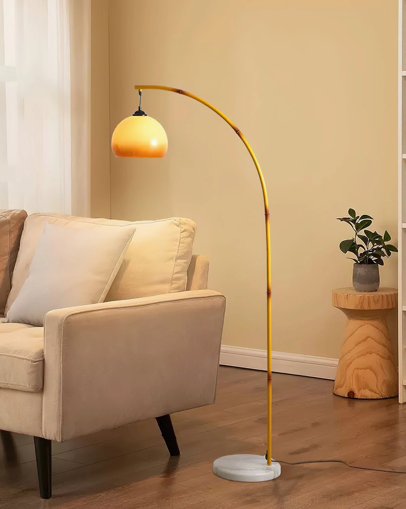Contemporary arc floor lamp with yellow pole and caramel shade in modern living room setting with sofa and side table