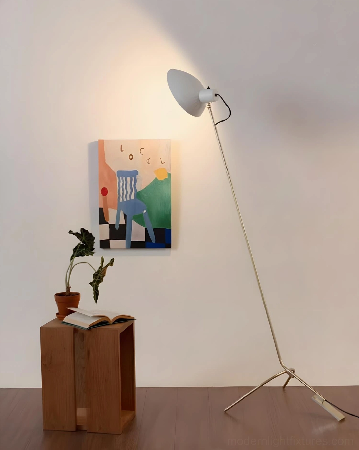 Contemporary arc floor lamp with white dome shade and brushed gold metal pole in minimalist interior with wall art