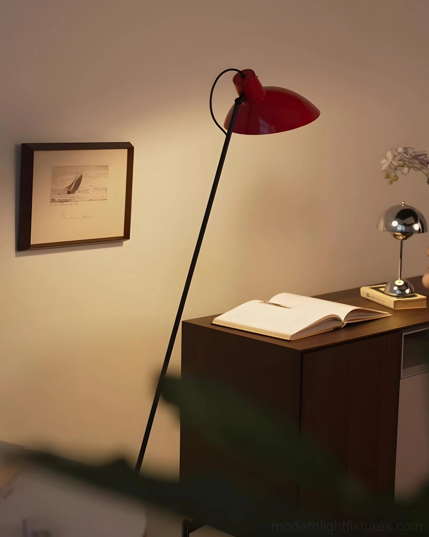 Modern arc floor lamp with red dome shade in minimalist home study setting with dark wood furniture