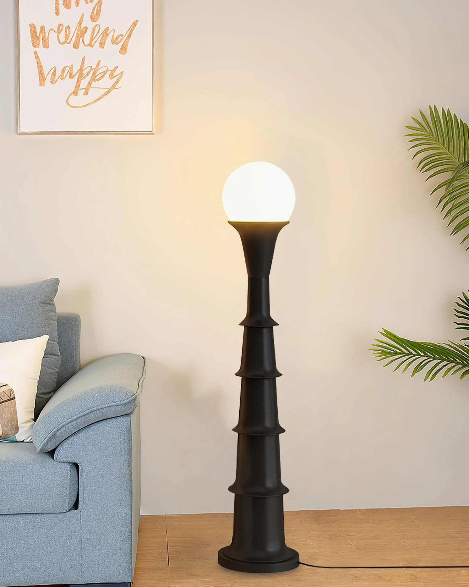 Black matte bamboo joint floor lamp three-quarter view in modern living room with blue sofa, architectural lighting design