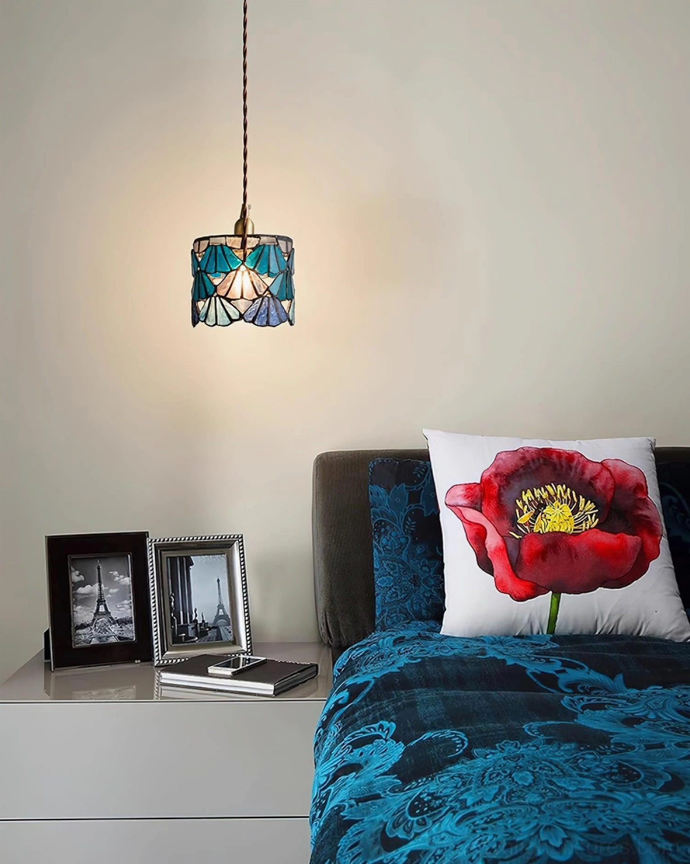 Blue Tina pendant lamp illuminating modern living room corner with blue patterned bedding and tabletop decor