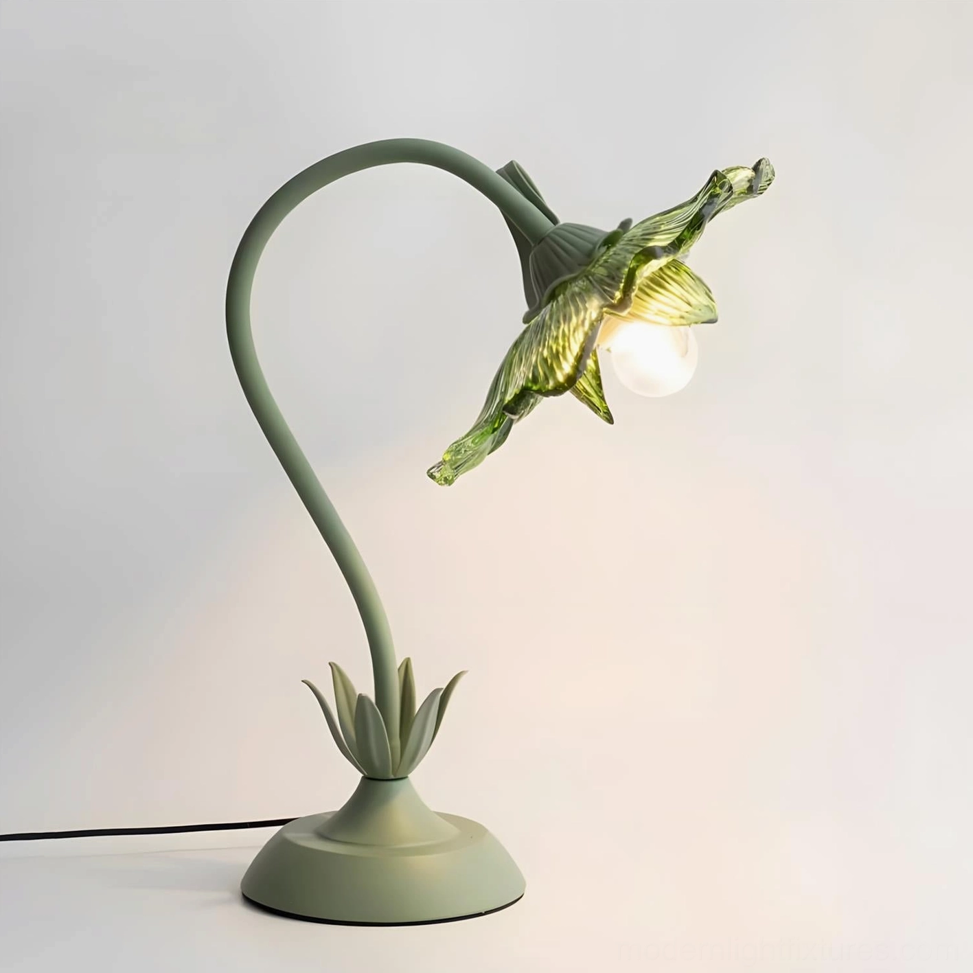 Left rear angle of botanical lamp displaying leafy base ornament and smooth mint green metal finish