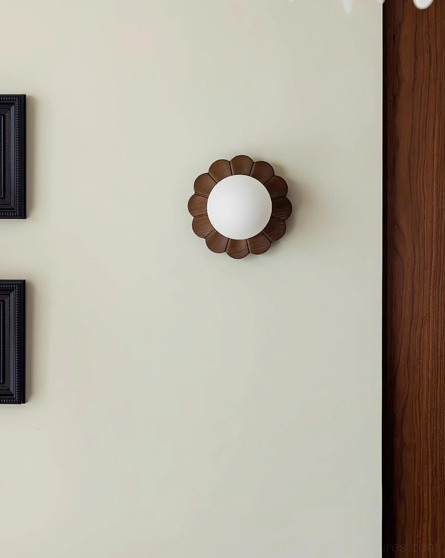 Contemporary wood and glass wall sconce mounted beside framed artwork on accent wall