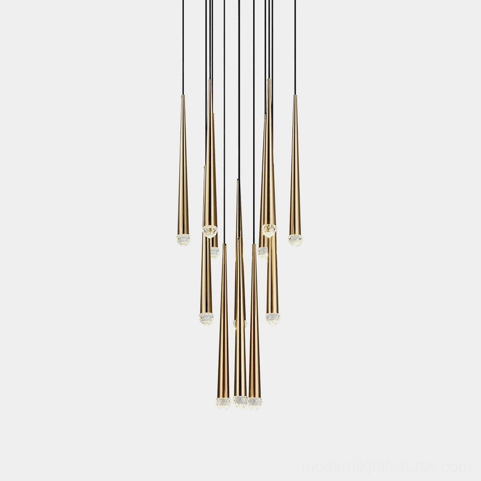 Modern brass cluster chandelier with suspended tapered rod elements on white background