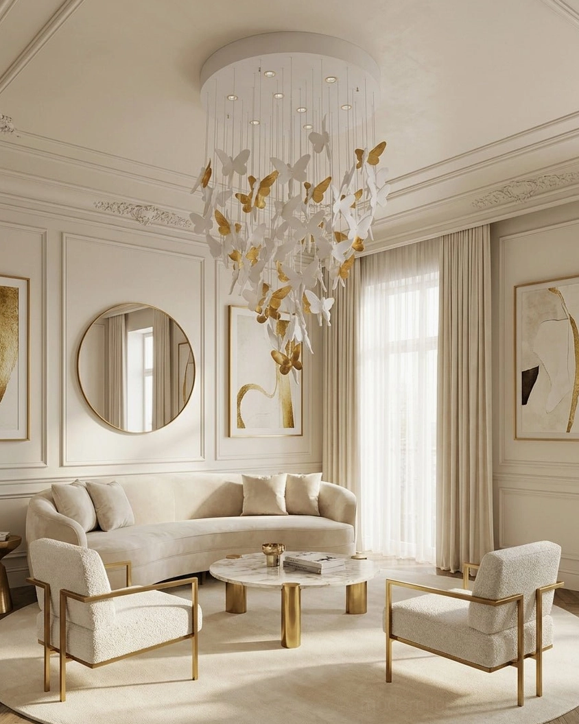 White and gold butterfly chandelier in neoclassical living room with tufted furniture and round wall mirror
