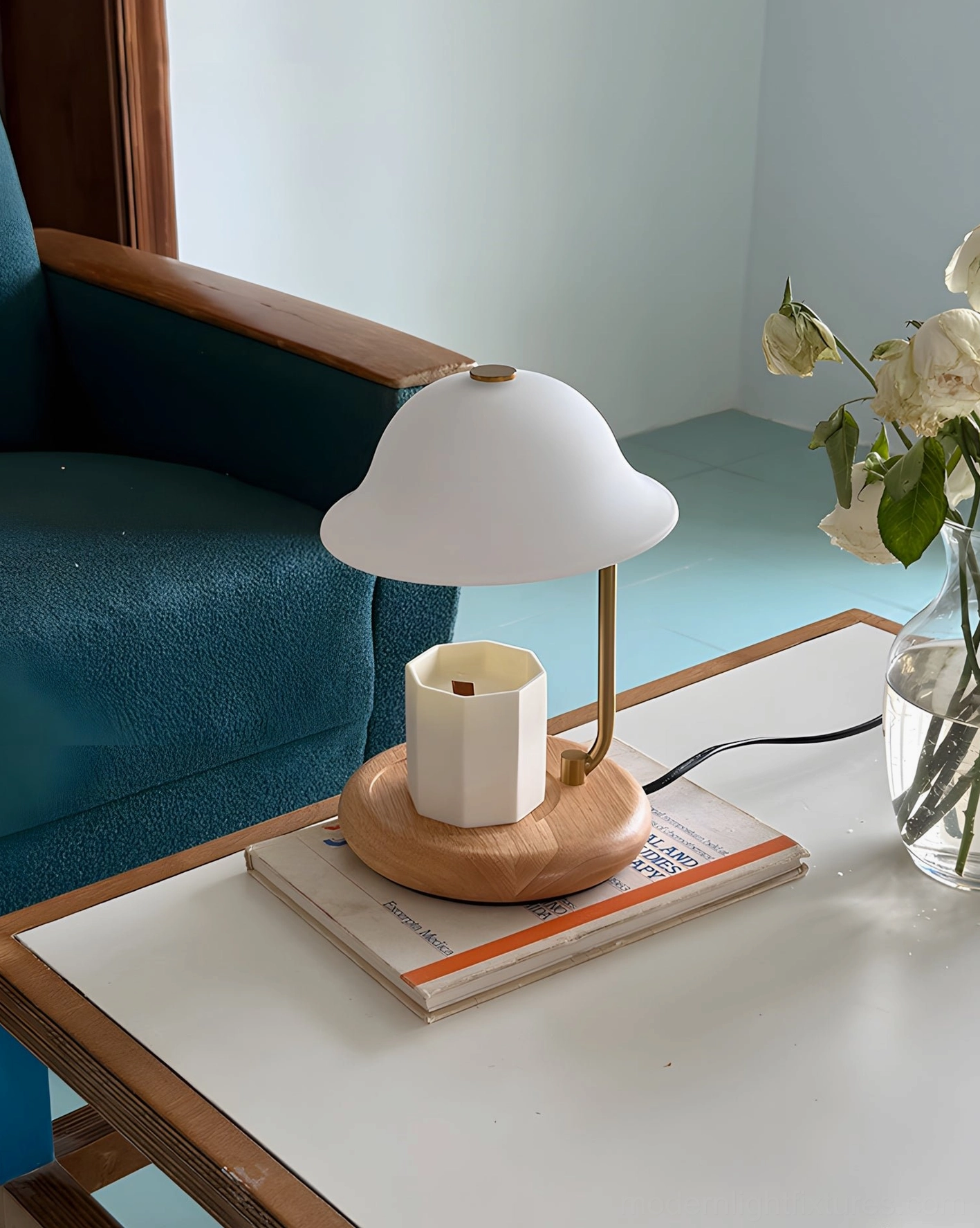 Minimalist candle warmer lamp with white shade and wood base in living room with teal accents