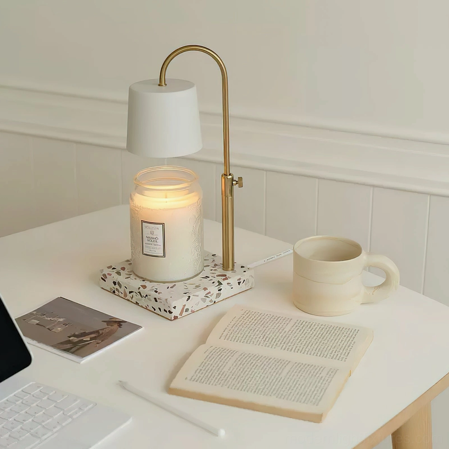 Minimalist candle warmer lamp white shade on home office desk with scented candle books and mug top-down view