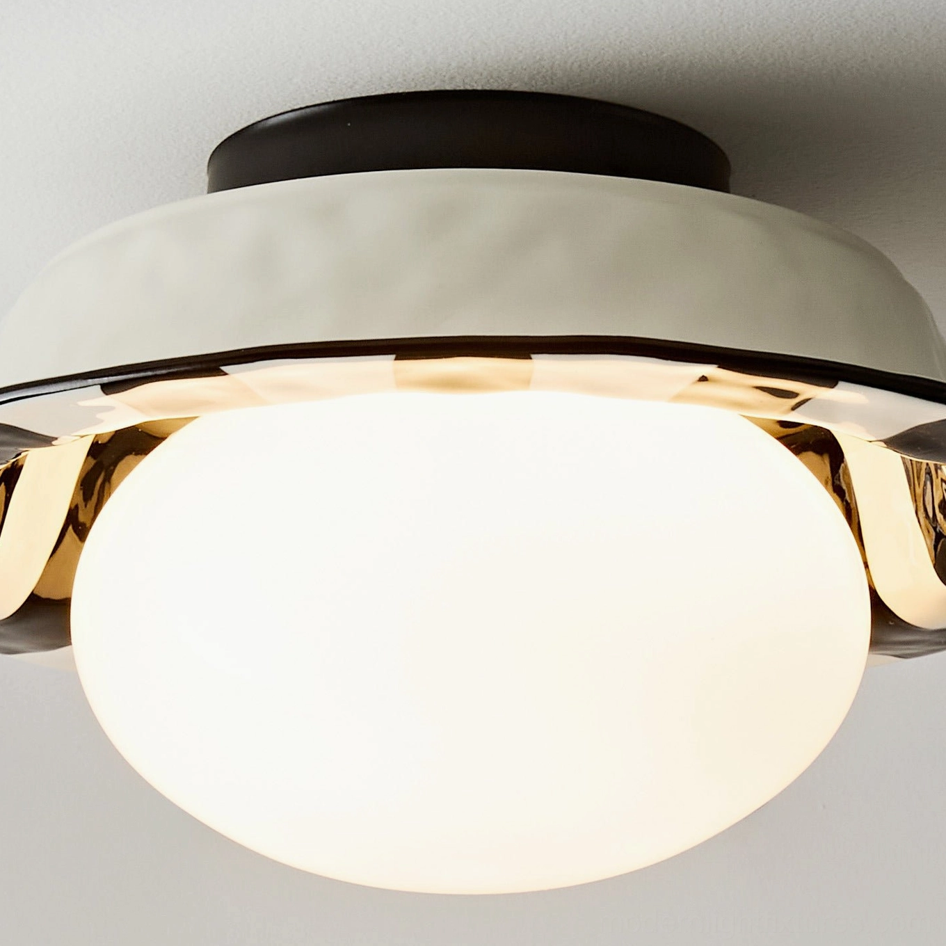 Extreme close-up of illuminated frosted spherical glass diffuser showing cream matte housing of checker ceiling fixture