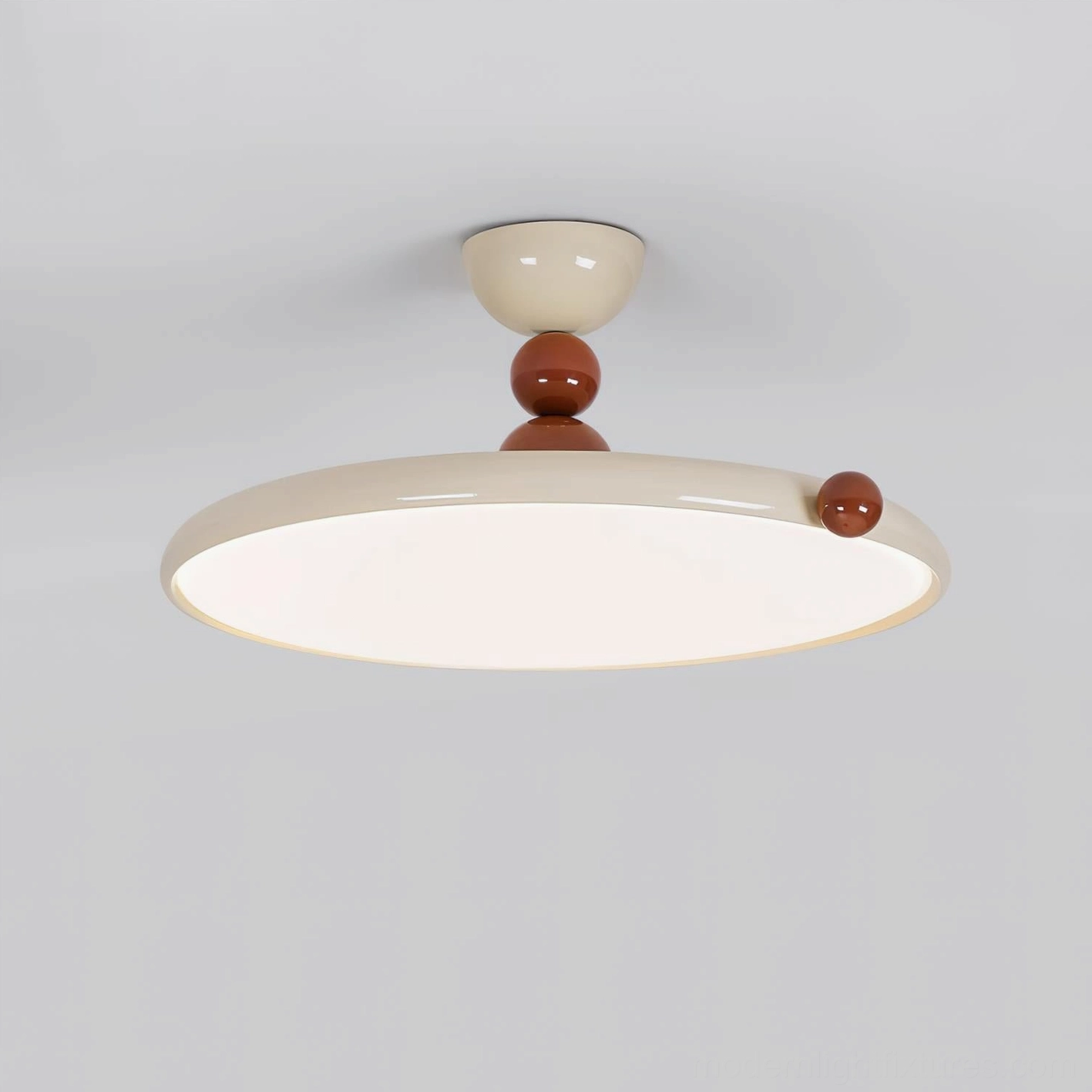 Front close-up view of illuminated modern disc ceiling lamp with cream diffuser and brown decorative detail