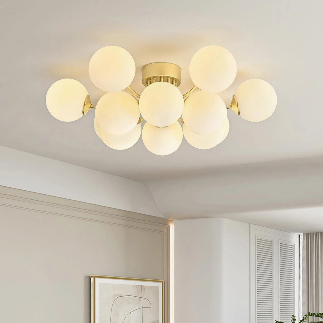 Multi-sphere flush mount ceiling light installed in residential interior showing brass accents and milky glass shades