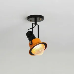 Adjustable ceiling light fixture with warm glowing bulb, two-tone black and orange design, overhead perspective