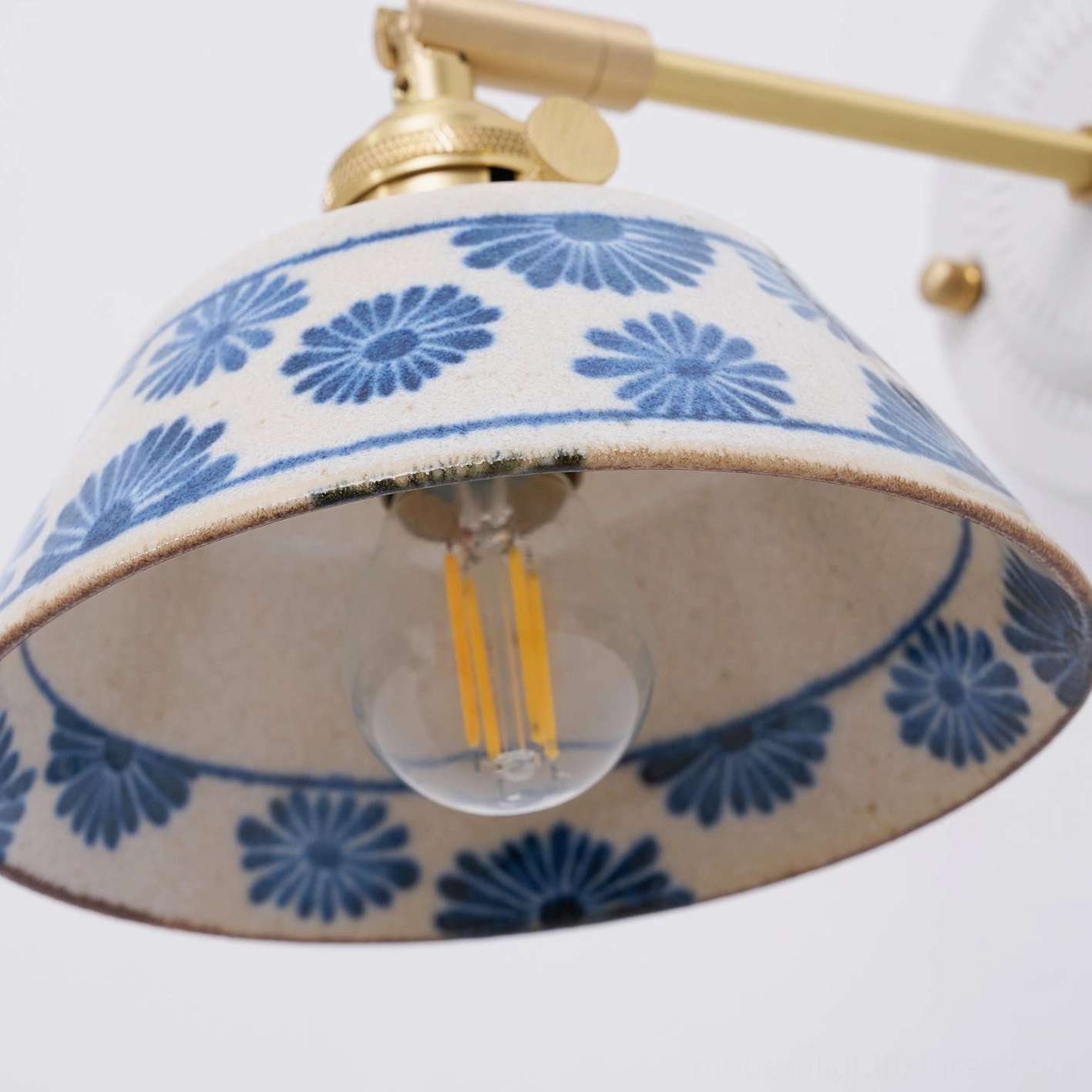 Modern ceramic wall lamp creating warm filtered light through hand-glazed shade