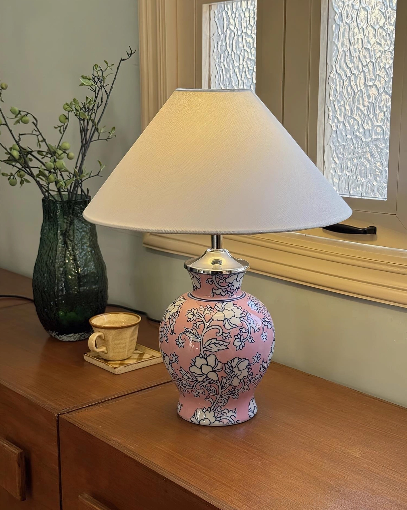 Modern ceramic floral table lamp with delicate botanical motifs and tapered fabric shade, contemporary home lighting