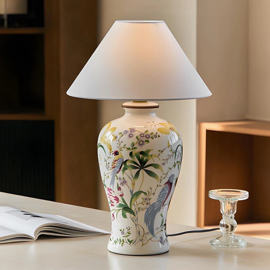 Modern ceramic table lamp with hand-painted botanical design on home office desk, off-white fabric shade three-quarter view
