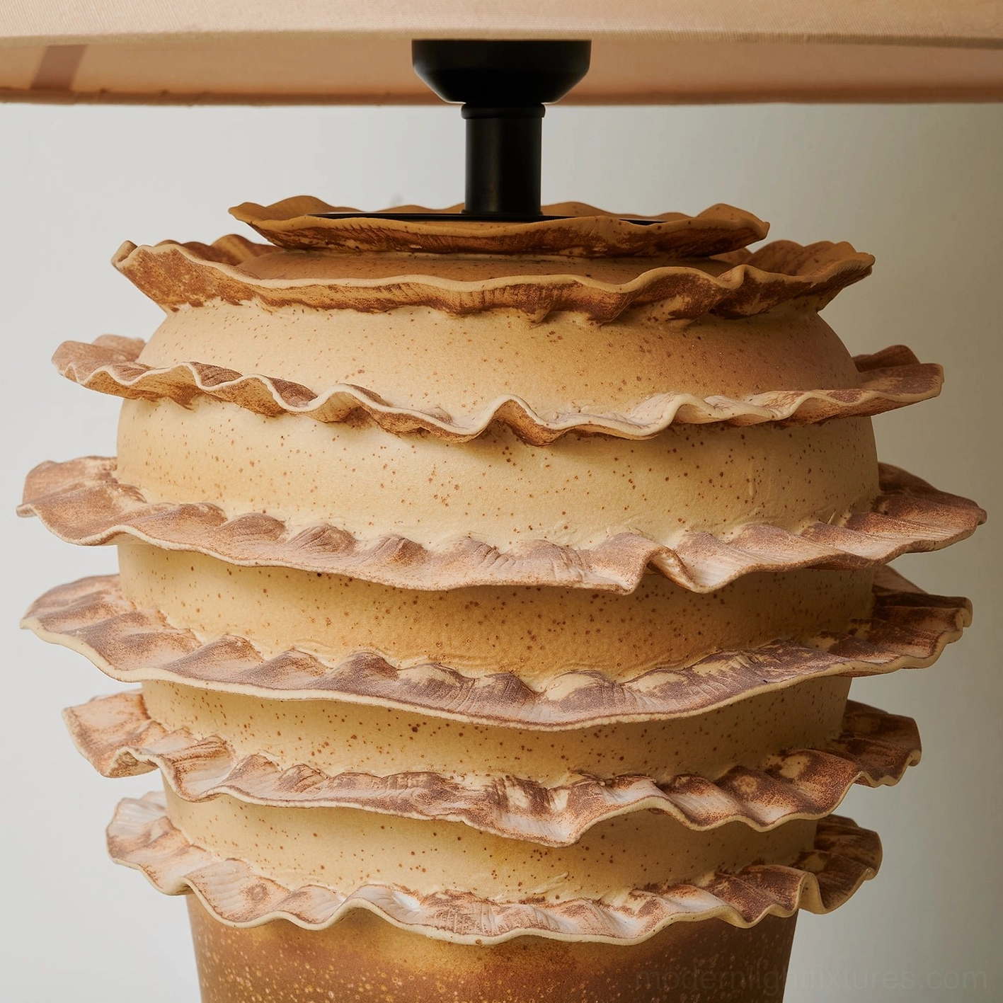 Modern ceramic table lamp with multi-tiered organic base in contemporary interior setting